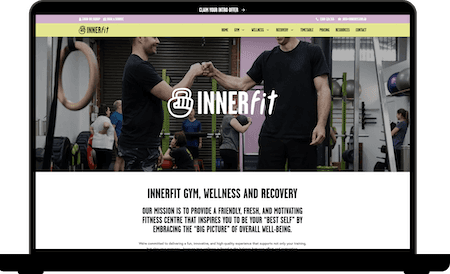 Laptop displaying a modern fitness website homepage for a gym and wellness brand